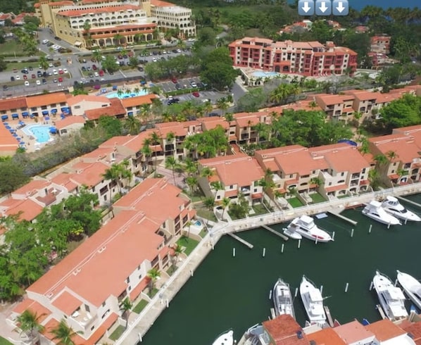 A coastal hotel with multiple buildings, a marina, and a beach nearby.