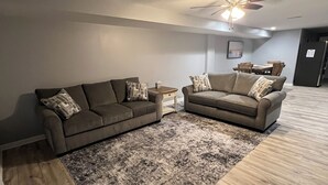 A living room with two sofas, a coffee table, and a rug.