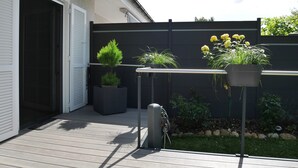 Una terraza de madera con plantas en macetas y una bicicleta.