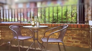 A balcony with two wicker chairs, a small round table, and a bottle of wine. - *NEW* Notting Hill - It's The One One One! (2) (London)