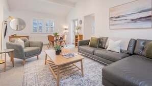 A spacious living room with a sofa, coffee table, and a dining area with chairs. - The Old Weigh House -Kirkby Lonsdale (Kirkby Lonsdale)