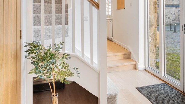 A modern interior with a wooden staircase, a large window, and a potted plant. - The Old Weigh House -Kirkby Lonsdale (Kirkby Lonsdale)