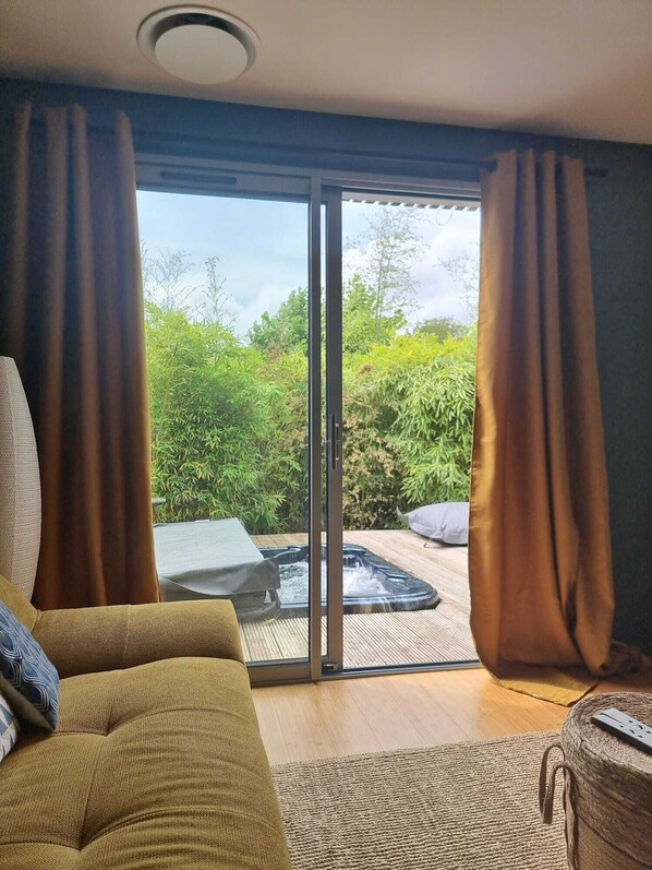 A room with a sofa, a small table, and a hot tub.