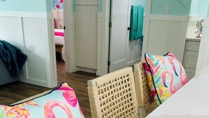 A room with a white marble table, wicker chairs, and a bed with a floral bedspread. - "The Salty Lime"  Walk to Restaurant/bars, park. (Port Richey)