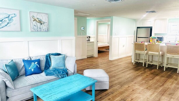 A living room with a sofa, a coffee table, and a dining area with chairs. - "The Salty Lime"  Walk to Restaurant/bars, park. (Port Richey)