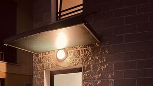A building entrance with a glass door, a metal awning, and a brick wall. - Venice Home perfect for Venice Airport free parking (Veneto)