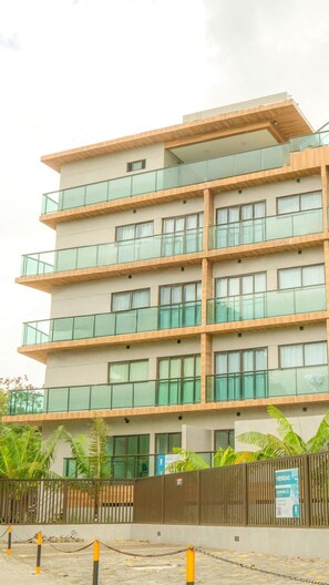 A multi-story building with balconies, large windows, and a gated entrance. - Green Porto Residence (Ipojuca)