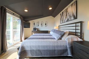 A bedroom with a large bed, a dresser, a coffee maker, and a painting on the wall. - Endless Views with a Private Indoor Heated Pool (Sevierville)