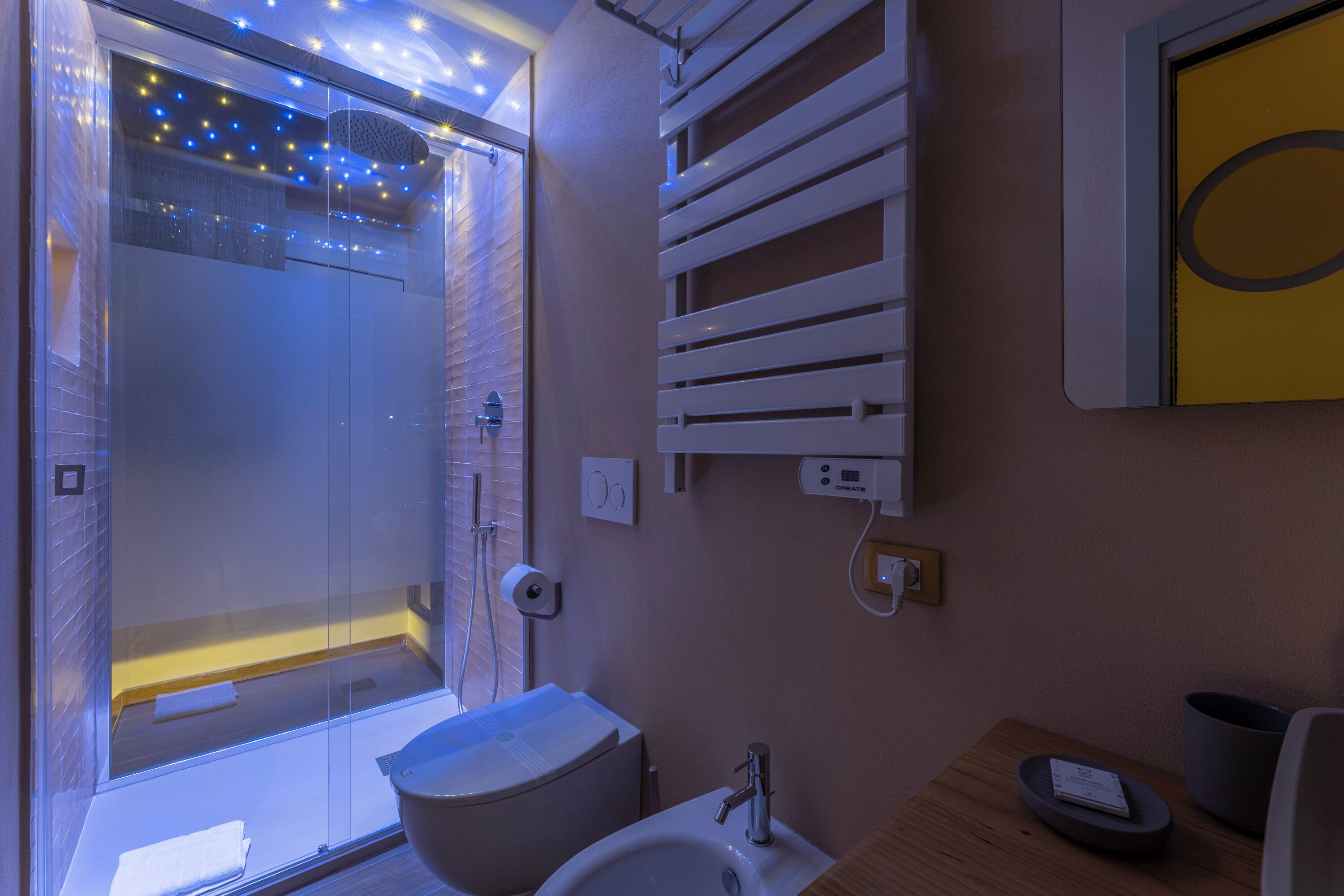 Ein modernes Badezimmer mit einer Duschkabine aus Glas, einem weißen Waschbecken und einem Handtuchhalter.