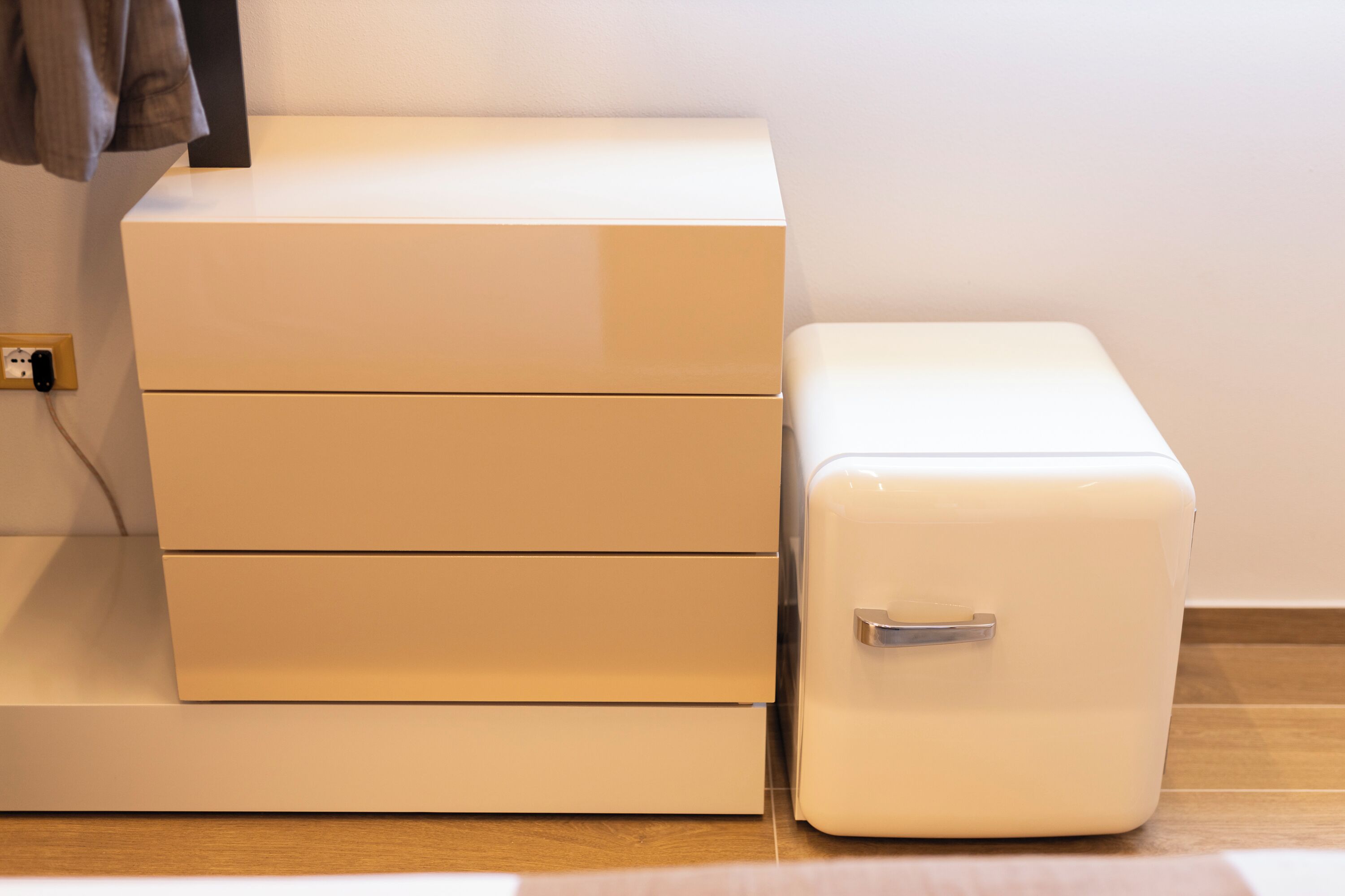 A white storage unit with drawers and a small white cabinet with a handle.