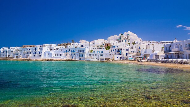 A coastal village with white buildings, clear turquoise sea, and rocky shoreline. - Paros VIP Pool Villa (Παροικιά)