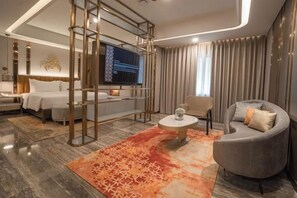 A modern hotel room with a bed, sofa, TV, and a decorative rug. - Grand Sahid Jaya CBD (Central Jakarta)