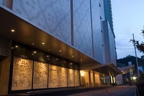 Une façade d’immeuble ornée de grandes peintures murales et dotée d’un espace d’entrée abrité.