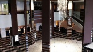 Un vestíbulo con piso a cuadros, una escalera y una lámpara colgante.