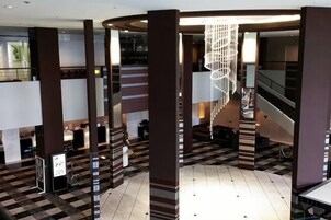 Un vestíbulo con piso a cuadros, una escalera y una lámpara colgante.