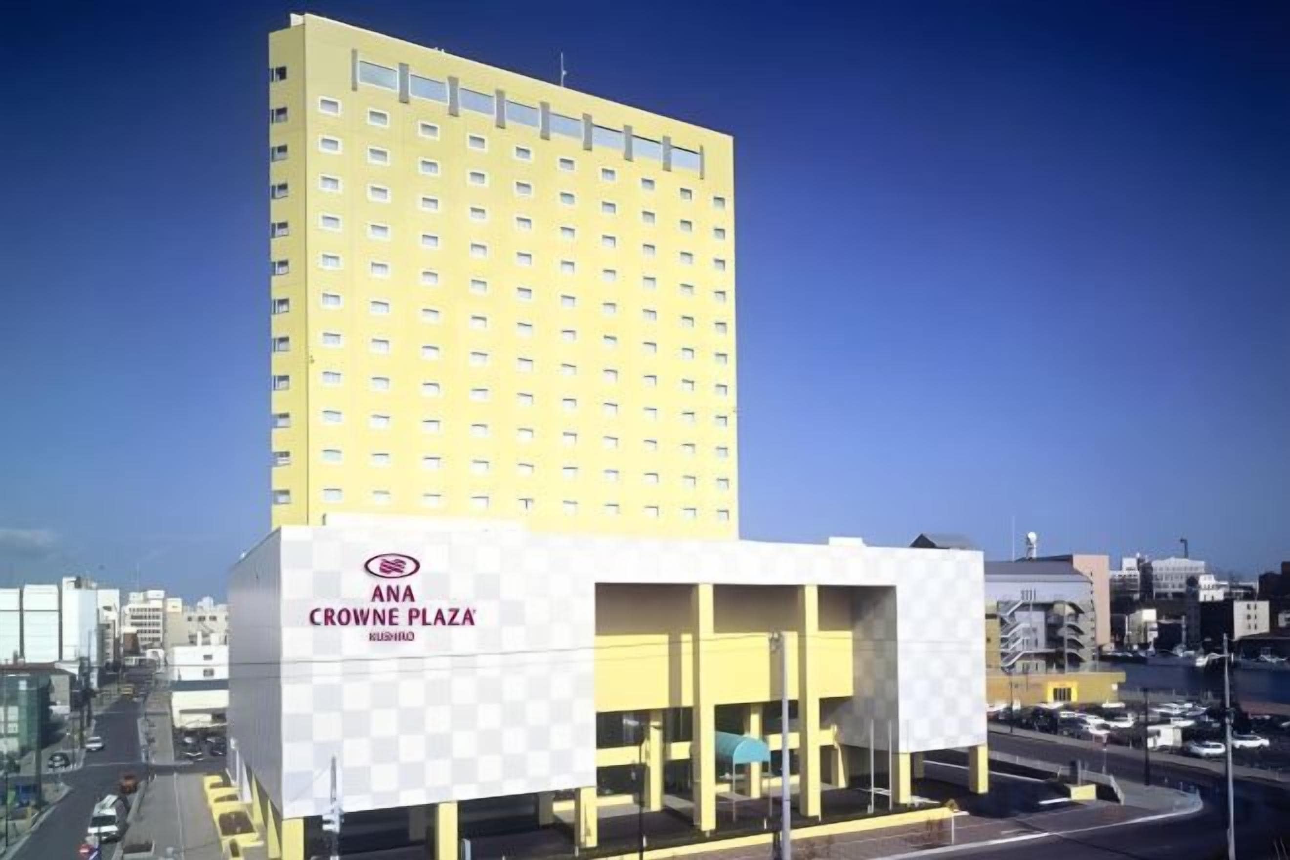 Un edificio de gran altura con fachada a cuadros y un letrero que dice 'ANA Crowne Plaza'.