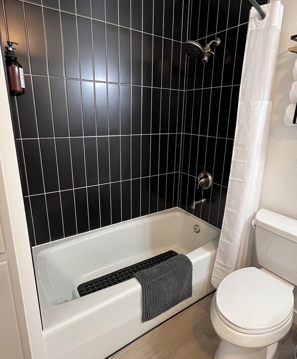 A bathroom with a bathtub, a shower, and a toilet.