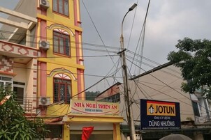 A building with a sign for 'NHÀ NHOI THIEN AN' and another sign for 'JOTUN DÌL THIÊN DUNG NHIUONG'.