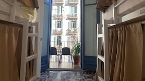 A corridor with a view of a balcony, a potted plant, and two chairs. - Sweet BCN Youth Hostel (Barcelona)