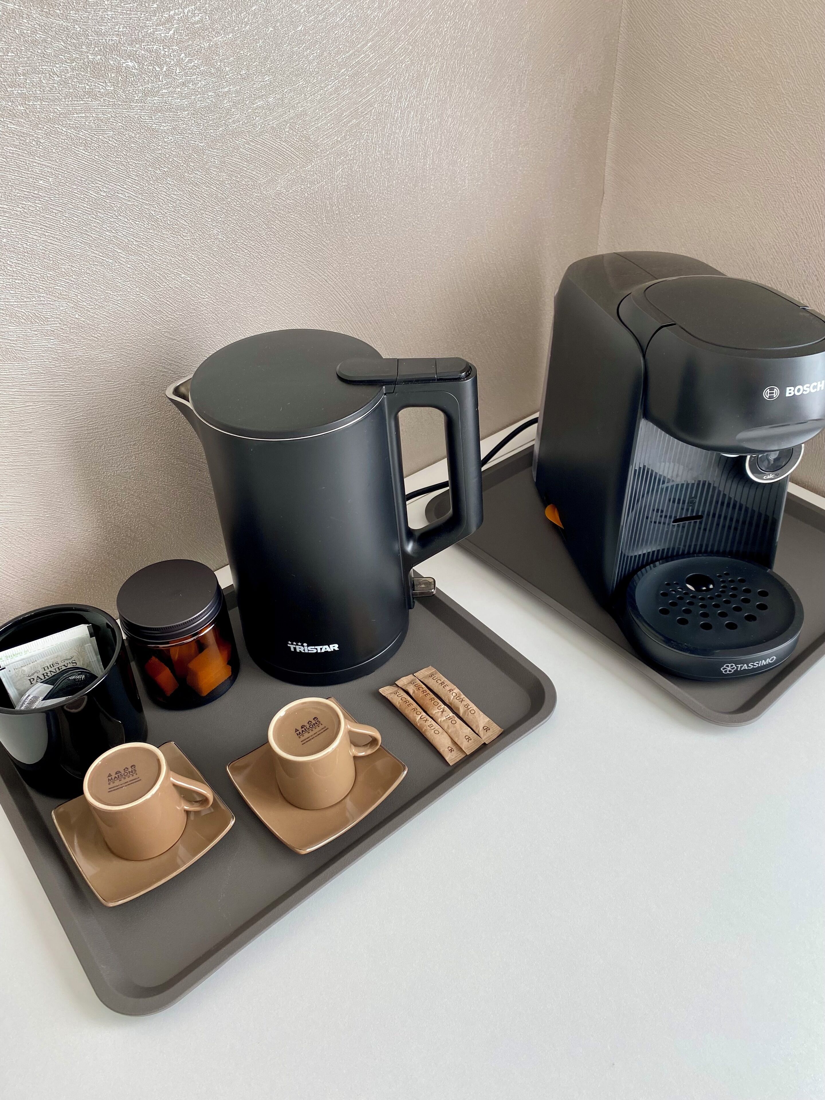 Eine Kaffeestation mit einer Bosch-Kaffeemaschine, einem Tristar-Kaffeekännchen und einem Tassimo-Kapselspender.