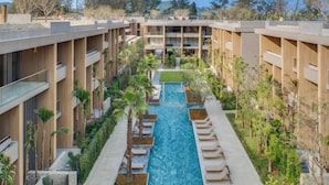 A modern hotel with a central swimming pool, multiple balconies, and lush landscaping. - Twinpalms MontAzure Phuket (Phuket)
