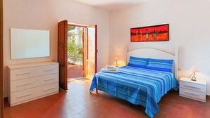 A bedroom with a bed, bedside tables, a dresser, and a painting on the wall.