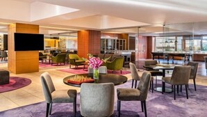 A modern hotel lobby with a large seating area, a flat-screen TV, and a bar/lounge area. - Grand Mercure Bengaluru at Gopalan Mall, An Accor Hotels Brand (Bengaluru)