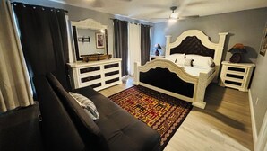 A bedroom with a bed, a dresser, a mirror, and a ceiling fan. - The Luxury Rustic Home, exceeding your expectations, not your budget! (Laredo)