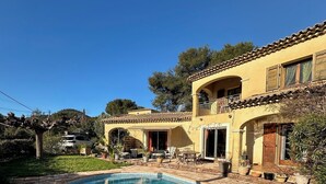 Un bâtiment à deux étages doté d’une piscine, entouré de verdure et d’arbres.