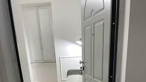 A bedroom with a bed, a wardrobe, and a door leading to another room. - Alice's House a stone's throw from the sea and the old town of Neptune (Nettuno)