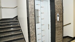 Een trap die leidt naar een lift met een deur met een patroon en een leuning.