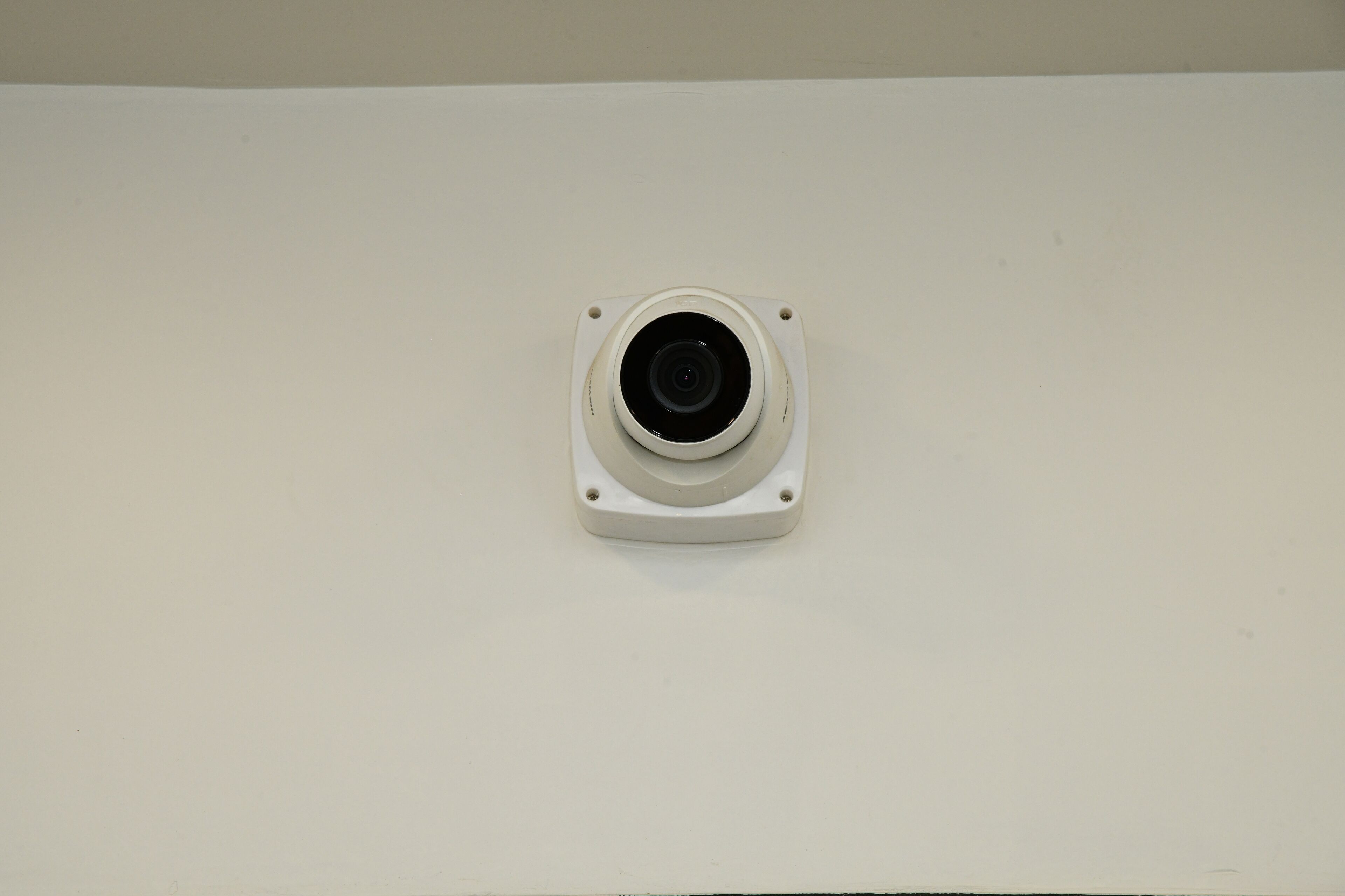 Una cámara de vigilancia montada en una pared blanca.