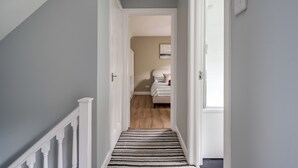 A hallway with a striped carpet leading to a bedroom with a bed and an air conditioner. - Stunning home over looking Belfast City, 11 minutes to City Centre (Castlereagh)