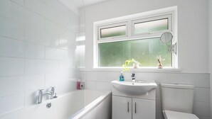 A modern bathroom with a white bathtub, a sink, and a toilet. - Stunning home over looking Belfast City, 11 minutes to City Centre (Castlereagh)