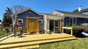 A house with a wooden deck, a covered patio, and a garage door.