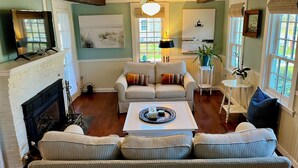 A living room with a fireplace, striped sofa, and a coffee table.