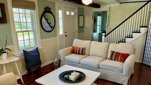 A living room with a striped sofa, a coffee table, and a dog.