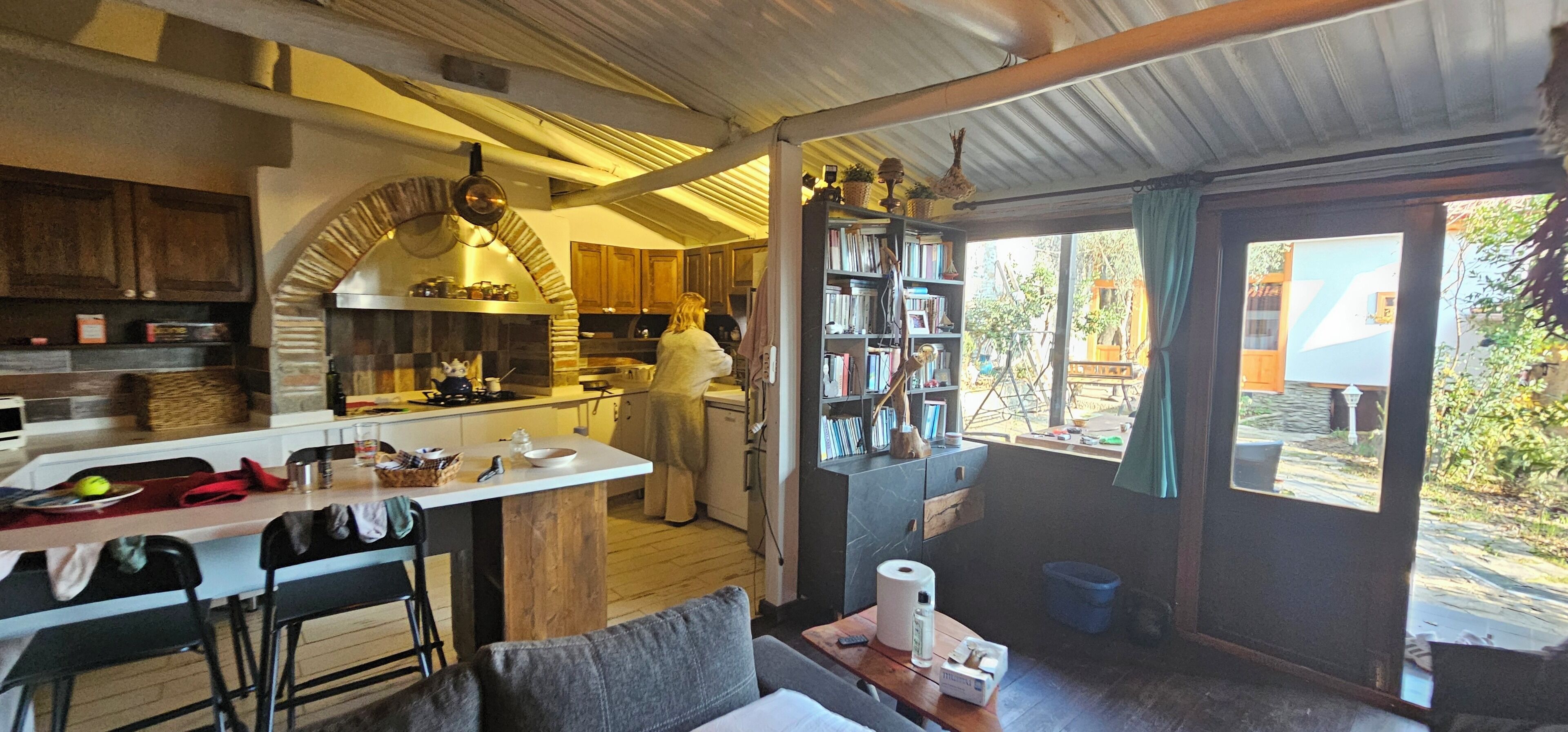 A kitchen with a stone oven, wooden cabinets, and a dining area with a table and chairs.
