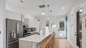 A modern kitchen with a large island, stainless steel appliances, and wooden bar stools. - Amazing Panoramic Views From This Luxury Retreat, Enjoy The Sauna On Top Deck. (Chattanooga)