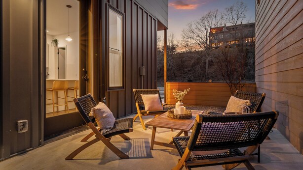 An outdoor seating area with four chairs and a table, a wooden bench, and a view of a building in the background. - Amazing Panoramic Views From This Luxury Retreat, Enjoy The Sauna On Top Deck. (Chattanooga)