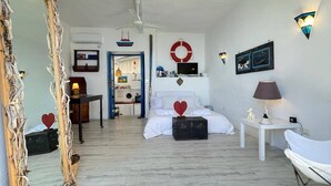 A bedroom with a bed, a dresser, a mirror, a desk, and a chair.