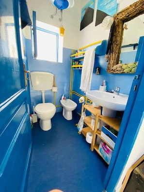 A compact bathroom with a toilet, bidet, and sink.