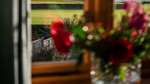 A view through a window with a coastal landscape, including rocky shores and a distant island. - Yellow Sands -  a house that sleeps 10 guests  in 5 bedrooms (Thurlestone)