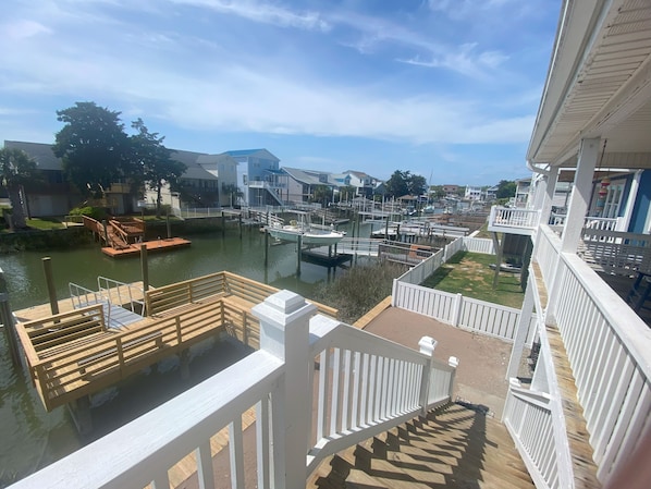 A marina with boats docked, wooden walkways, and a view of residential buildings in the background.