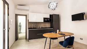 Eine moderne Küche mit Mikrowelle, Backofen und einem an der Wand befestigten Flachbildfernseher.