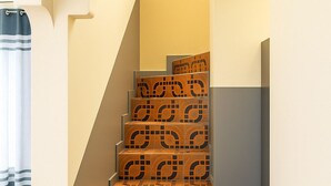 Un escalier orné de carreaux à motifs et doté d’un mur aux lignes courbes.