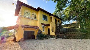 A yellow building with a tiled roof, stone walls, and a gravel driveway. - Panama View House (Panamá)