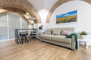Un salon moderne avec un canapé, une table basse et un tableau représentant un champ de tournesols.