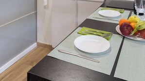 A kitchen with a brick wall, white cabinets, and a dining table set with plates, cutlery, and fruit. - Two steps from theColosseum brand new apartment with maximum comfort for family (Roma)