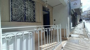 Ein Gebäude mit einem weißen Balkon, dekorativen Metallgeländern und einem fensterartigen Zierelement.
